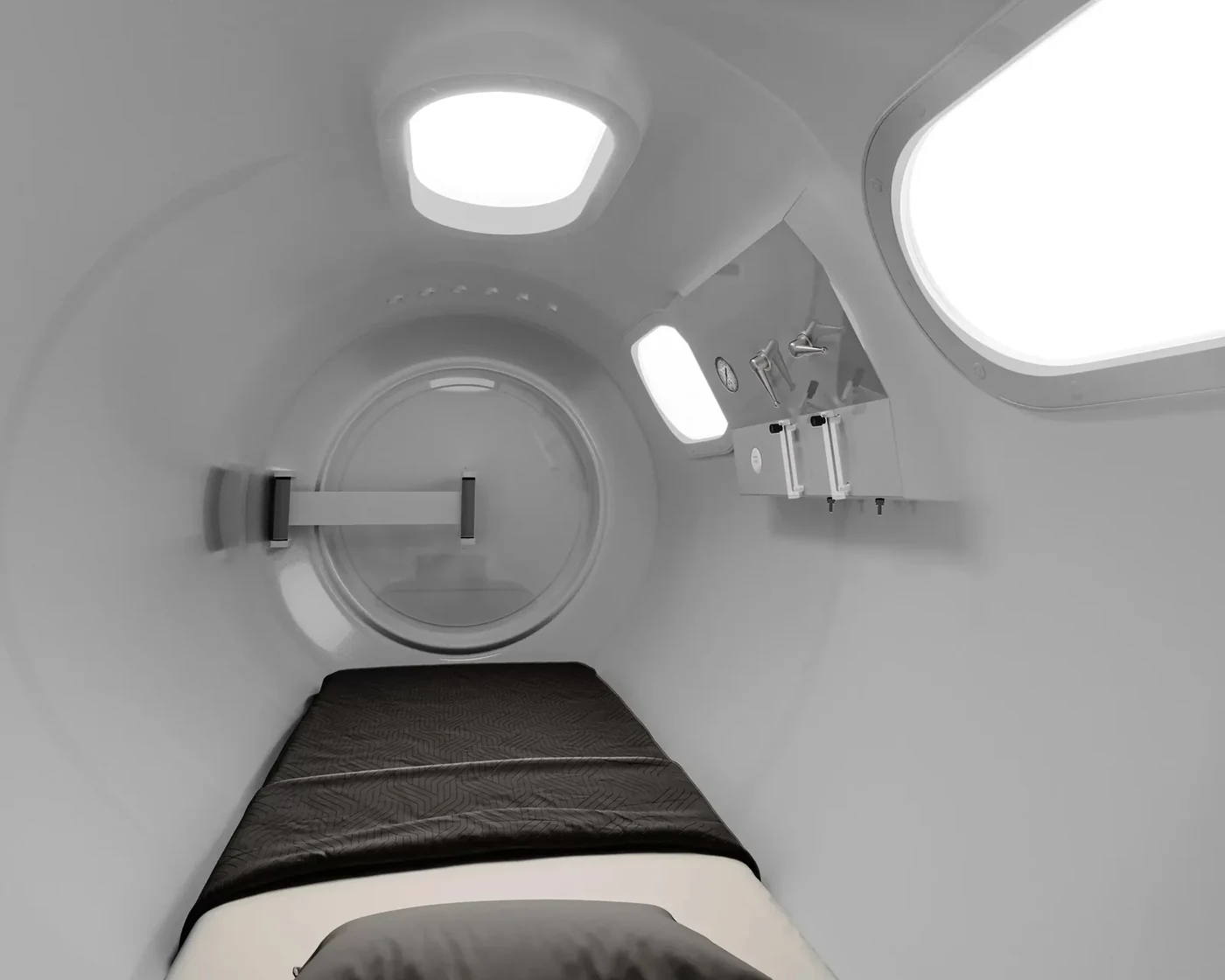 Inside The Alexander hyperbaric chamber — full-length bed, viewing windows and interior lighting